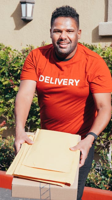 Inside a residential property, a man from Man with Van Loxford is engaged in a home relocation process during daylight hours. He is standing near an open doorway with a beige wall and outdoor lighting